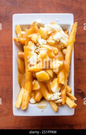 Piatto di poutine con patatine croccanti condite con cagliate di formaggio e ricco sugo di carne bruno in un ristorante locale di Alberta, Canada Foto Stock