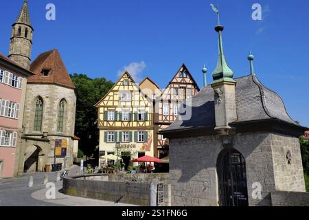 Il ponte Henkersbruecke a Schwaebisch Hall attraversa il fiume Kocher. Di fronte alla chiesa di Johanniter e ad una disposizione di splendidi edifici in legno Foto Stock