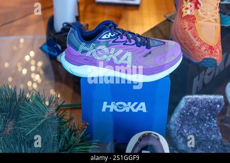 Foto ravvicinata di una scarpa Hoka viola in una vetrina in un negozio di scarpe. Le scarpe Hoka hanno conquistato il mondo delle corse negli ultimi anni. Foto Stock