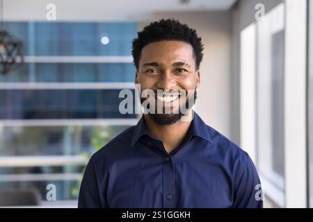 Allegro e grazioso giovane uomo d'affari afroamericano che posa per un colpo alla testa Foto Stock