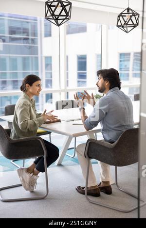 Due giovani partner commerciali indiani impegnati in conversazione Foto Stock