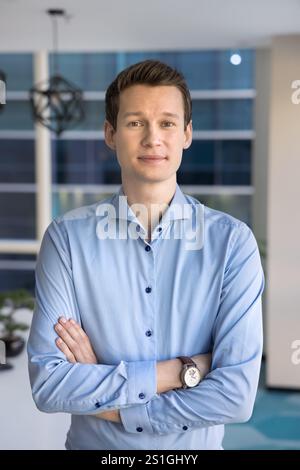 Positivo giovane uomo leader di affari caucasico in posa in ufficio Foto Stock
