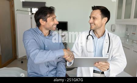 Medico sicuro e paziente felice che stringe la mano Foto Stock