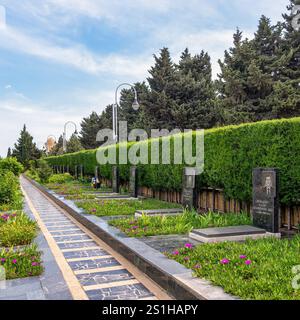 Baku, Azerbaigian - 6 maggio 2024: Vicolo dei Martiri, con ritratti commemorativi tra alberi verdeggianti e un'atmosfera tranquilla Foto Stock