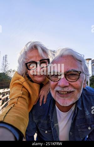 Felice coppia caucasica senior che si fa un selfie all'aperto insieme, godendosi la vita in pensione e l'amore. Foto Stock