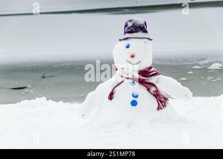 One eye smiling snowman standing under the snow Foto Stock