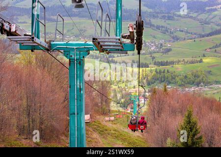 Esplorate le tranquille colline mentre viaggiate in funivia attraverso la vegetazione lussureggiante in primavera Foto Stock