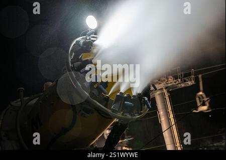 Snow Gun Making Snow at Night on the Ski Slope. Impianto di innevamento al lavoro. Foto Stock