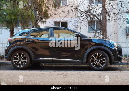 Bucarest, Romania – 4 gennaio 2025: Vista laterale dell'auto nera ibrida Ford Puma parcheggiata sulla strada di fronte al blocco di appartamenti Foto Stock