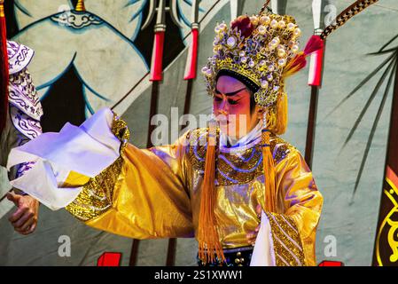 Artisti d'opera cinesi tradizionali che mostrano intricati costumi ed espressioni drammatiche durante le celebrazioni del capodanno cinese nel quartiere cinese di Chinatow di Bangkok Foto Stock