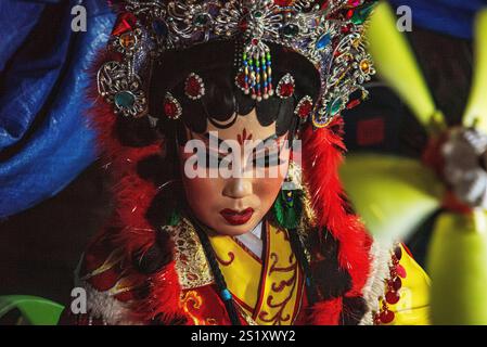 Artisti d'opera cinesi tradizionali che mostrano intricati costumi ed espressioni drammatiche durante le celebrazioni del capodanno cinese nel quartiere cinese di Chinatow di Bangkok Foto Stock