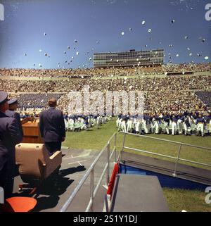 KN-C29045 5 giugno 1963 viaggio del presidente John F. Kennedy in Colorado per affrontare la classe di laurea presso la U.S. Air Force Academy. I cadetti che si laureano lanciano berretti in aria mentre il presidente Kennedy guarda avanti. Falcon Stadium, U.S. Air Force Academy, Colorado Springs, Colorado. Foto Stock