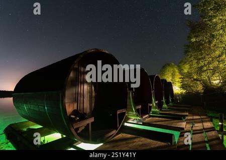 Notte in botte: Insoliti glamping sulla riva del lago sotto un cielo stellato. Accoglienti casette a botte per una fuga romantica. Foto Stock