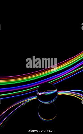 Una luce colorata si diffonde in una fotografia a lunga esposizione intorno a una sfera di vetro su uno specchio. Riflessi e vortici di sfondo luminoso Foto Stock