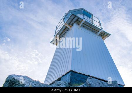 Vecchio faro su una costa rocciosa, vista dal basso. Foto Stock