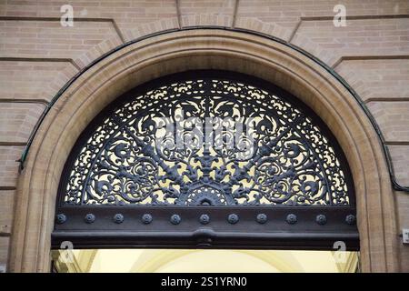 Ornate di ferro adornano un arco a Tolosa, mettendo in risalto il ricco patrimonio architettonico della città. Foto Stock