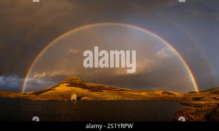Un doppio arcobaleno che si innalza sulla casetta di Devoke Water nel Lake District Foto Stock