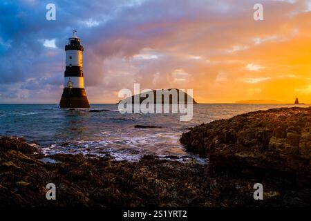Alba al faro di Penmon (faro di Trwyn Du), Puffin Island (Ynys Seiriol) e Perch Rock Beacon, Penmon Point ad Anglesey, Galles del Nord Foto Stock
