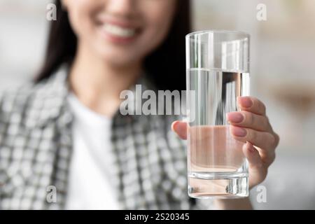 Bicchiere d'acqua in mano di giovane donna, primo piano Foto Stock