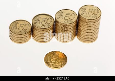 Alcune pile di monete in euro su sfondo bianco Foto Stock