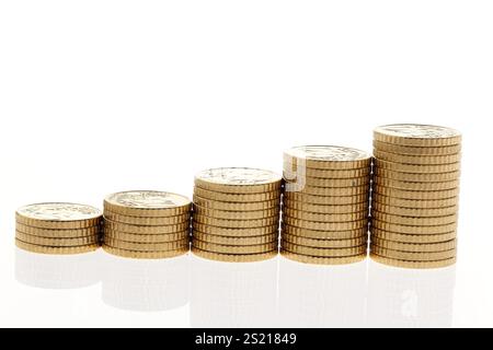 Alcune pile di monete in euro su sfondo bianco Foto Stock