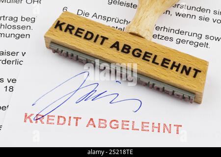 Un timbro di legno giace su un documento. Iscrizione tedesca: Kredit abgelehnt Austria Foto Stock