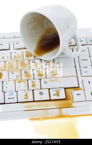 Tazza di caffè versata sulla tastiera del computer. Danni assicurativi, tazza di caffè versata sulla tastiera di un computer. Assicurazione contro i danni. Austria Foto Stock
