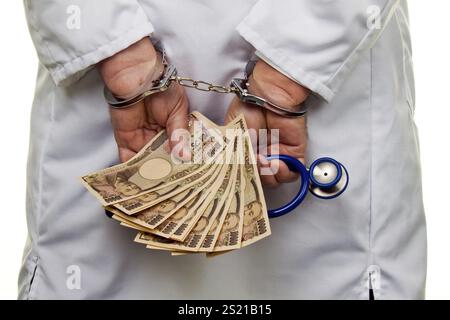 Un medico con banconote e manette in YEN giapponesi in Austria Foto Stock
