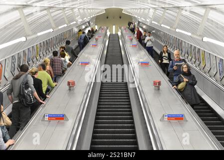 Persone che viaggiano su e giù per una lunga scala mobile in una stazione della metropolitana, Londra, regione di Londra, Inghilterra, Regno Unito, Europa Foto Stock