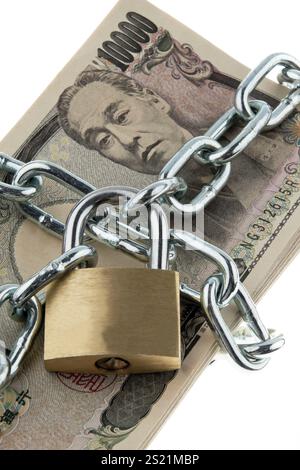 Banconote in yen giapponesi con serratura e catena. Un insieme di soldi per la sicurezza e gli investimenti Foto Stock