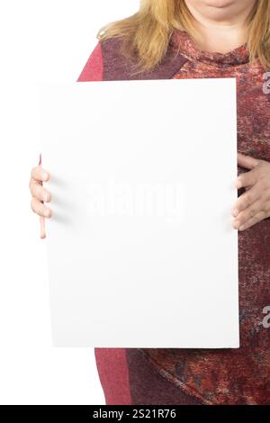 Primo piano verticale di una donna che tiene in mano un poster bianco vuoto, perfetto per testo o disegni personalizzati. La donna indossa un sudore rosso e fantasia Foto Stock