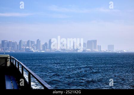 San Diego, California, Stati Uniti. 21 dicembre 2024. Lo skyline del centro di San Diego emerge attraverso una nebbia leggera, creando una vista soffusa ma suggestiva dell'architettura moderna della città. Gli edifici torreggianti sono incorniciati dalle calme acque della Baia di San Diego, con il Ponte Coronado ben visibile in lontananza. Questa suggestiva scena cattura l'interazione tra la vivacità urbana e la tranquillità costiera, mostrando il caratteristico fascino del lungomare di San Diego. (Credit Image: © Ian L. Sitren/ZUMA Press Wire) SOLO PER USO EDITORIALE! Non per USO commerciale! Foto Stock