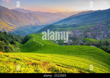 il villaggio di tian tou zhai visto dal punto di osservazione la musica numero 1 dal paradiso nella terrazza di riso di longji, in cina. La luce del sole colpisce le risaie nella m Foto Stock