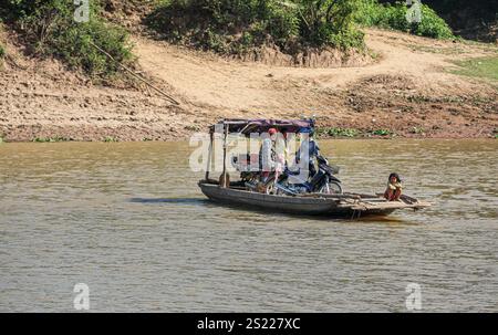 Fiume Mekong, Cambogia. 05 gennaio 2025: Un piccolo rudimentale traghetto in legno, forse uno dei traghetti più piccoli del mondo, navette da una riva all'altra attraverso il fiume, uno dei canali d'acqua più lunghi dell'Asia. Il fiume, che attraversa sei paesi dalla Cina al Vietnam, è al centro della vita quotidiana della popolazione che vive lungo il famoso corso d'acqua, da tempo celebrato per il suo esotismo nella letteratura e nel cinema. Sul lato cambogiano, la maggior parte delle rive del fiume sono ancora nel loro stato naturale, rendendole soggette all'erosione a causa del controllo del flusso d'acqua a monte (dighe cinesi) o del dragaggio della sabbia. Crediti: Kevin Izorce/Alamy Live News Foto Stock
