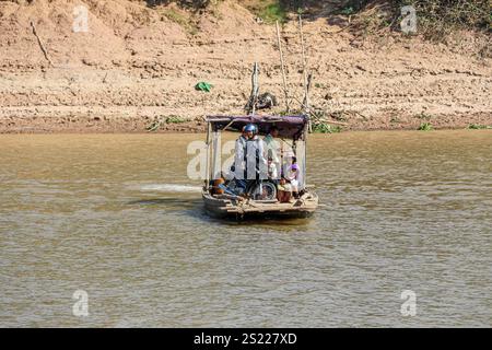 Fiume Mekong, Cambogia. 05 gennaio 2025: Un piccolo rudimentale traghetto in legno, forse uno dei traghetti più piccoli del mondo, navette da una riva all'altra attraverso il fiume, uno dei canali d'acqua più lunghi dell'Asia. Il fiume, che attraversa sei paesi dalla Cina al Vietnam, è al centro della vita quotidiana della popolazione che vive lungo il famoso corso d'acqua, da tempo celebrato per il suo esotismo nella letteratura e nel cinema. Sul lato cambogiano, la maggior parte delle rive del fiume sono ancora nel loro stato naturale, rendendole soggette all'erosione a causa del controllo del flusso d'acqua a monte (dighe cinesi) o del dragaggio della sabbia. Crediti: Kevin Izorce/Alamy Live News Foto Stock