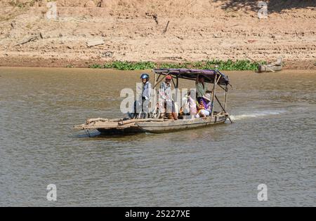 Fiume Mekong, Cambogia. 05 gennaio 2025: Un piccolo rudimentale traghetto in legno, forse uno dei traghetti più piccoli del mondo, navette da una riva all'altra attraverso il fiume, uno dei canali d'acqua più lunghi dell'Asia. Il fiume, che attraversa sei paesi dalla Cina al Vietnam, è al centro della vita quotidiana della popolazione che vive lungo il famoso corso d'acqua, da tempo celebrato per il suo esotismo nella letteratura e nel cinema. Sul lato cambogiano, la maggior parte delle rive del fiume sono ancora nel loro stato naturale, rendendole soggette all'erosione a causa del controllo del flusso d'acqua a monte (dighe cinesi) o del dragaggio della sabbia. Crediti: Kevin Izorce/Alamy Live News Foto Stock
