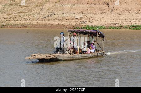Fiume Mekong, Cambogia. 05 gennaio 2025: Un piccolo rudimentale traghetto in legno, forse uno dei traghetti più piccoli del mondo, navette da una riva all'altra attraverso il fiume, uno dei canali d'acqua più lunghi dell'Asia. Il fiume, che attraversa sei paesi dalla Cina al Vietnam, è al centro della vita quotidiana della popolazione che vive lungo il famoso corso d'acqua, da tempo celebrato per il suo esotismo nella letteratura e nel cinema. Sul lato cambogiano, la maggior parte delle rive del fiume sono ancora nel loro stato naturale, rendendole soggette all'erosione a causa del controllo del flusso d'acqua a monte (dighe cinesi) o del dragaggio della sabbia. Crediti: Kevin Izorce/Alamy Live News Foto Stock