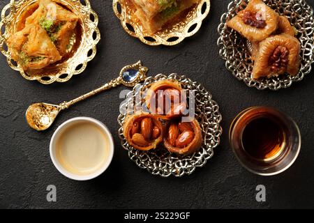 Dolci tradizionali mediorientali serviti con caffè arabo su piatti decorativi in un ambiente elegante Foto Stock