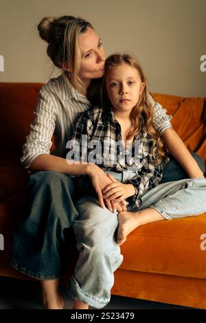 Mamma e figlia si abbracciano a casa Foto Stock