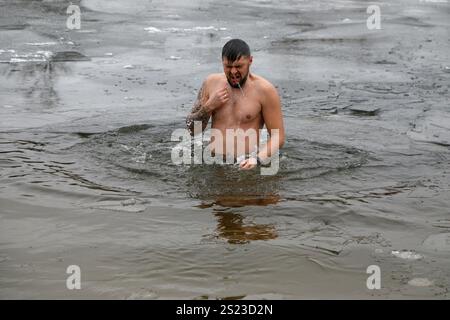 KIEV, UCRAINA - 6 GENNAIO 2025 - Un uomo si tuffa a Hidropark sull'Epifania, Kiev, capitale dell'Ucraina. Foto Stock