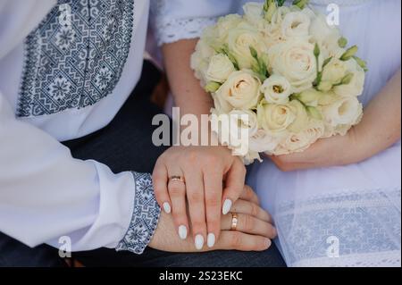 Romantico momento di nozze con mani e bouquet che mostrano amore e impegno. Foto Stock