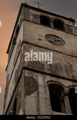 Scaglie provenienti dalle pareti esterne di un campanile romanico che sorge accanto alla chiesa di San Giorgio il giovane, risalente alla fine del XV secolo, nella città fortificata di Plomin, provincia dell'Istria, Croazia, oggi per lo più disabitata. Foto Stock