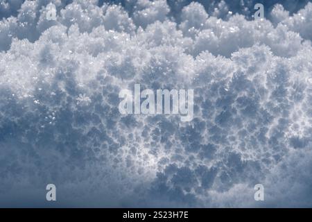 ipnotico primo piano di delicati cristalli di ghiaccio che brillano nella luce, catturando l'intricata bellezza delle gelate in un'atmosfera serena e ventosa Foto Stock