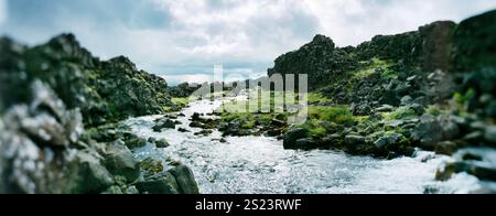 Vista panoramica del fiume che scorre dalla cascata Öxarárfoss o dalla cascata Oxararfoss al parco nazionale di Thingvellir nel cerchio dorato, islanda, Scan Foto Stock