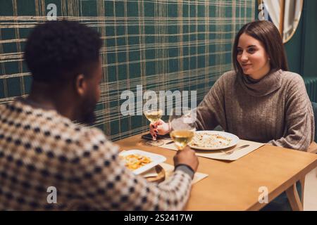 Due amici cenano al ristorante. Sono seduti, parlano e si divertono insieme. Foto Stock