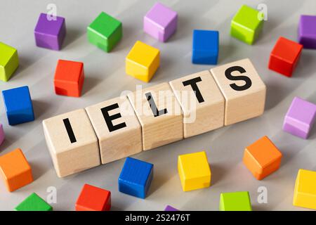IELTS scritto su blocchi di legno (International English Language Testing System) parola concettuale, istruzione e lavoro in organizzazioni internazionali requ Foto Stock