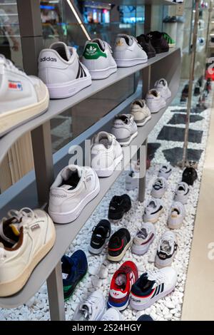 Un'ampia selezione di scarpe sportive casual di varie marche in un moderno interno di un negozio di scarpe sportive. Minsk, Bielorussia - 1 giugno 2024 Foto Stock