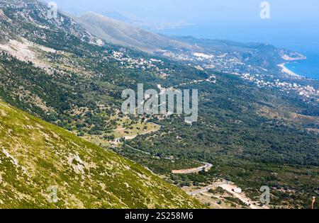 Vista della costa nebbiosa estiva dal passo di Llogara e dalla città sul versante della montagna (Albania) Foto Stock