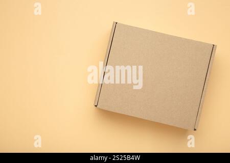Scatola di carta marrone scatola di cartone su sfondo beige. Vista dall'alto Foto Stock