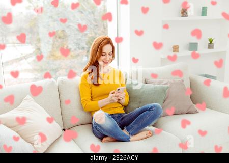 Bello, magnifico, squisito, delicato, ventoso, amabile donna seduto su un comodo divano con maglione giallo e jeans in denim in un moderno interno luminoso Foto Stock